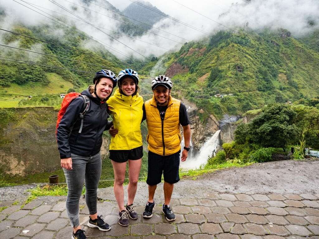 Friends standing in front of waterfalls in Baños Ecuador