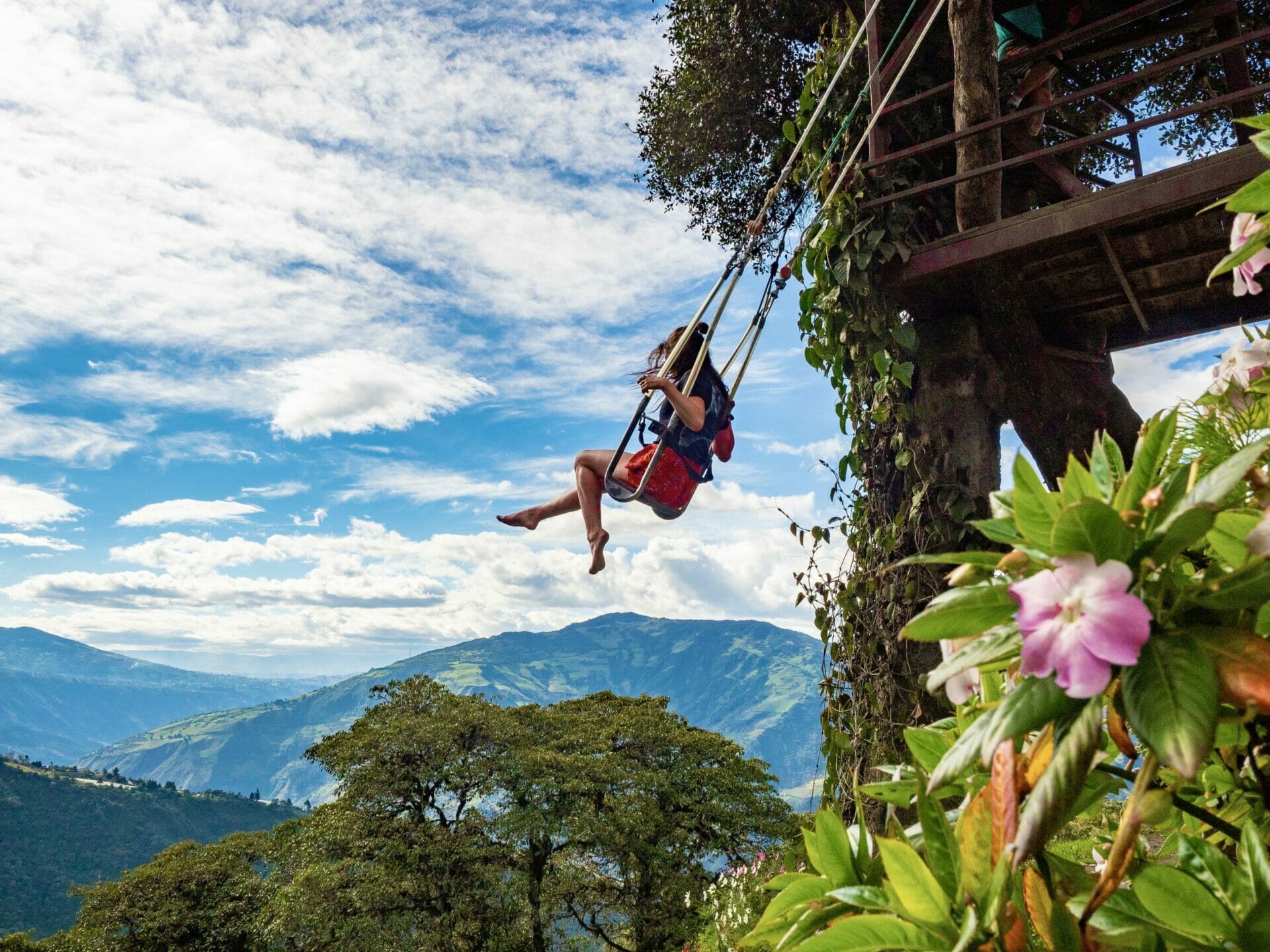 Girl swinging over mountains Casa del Arbol Baños